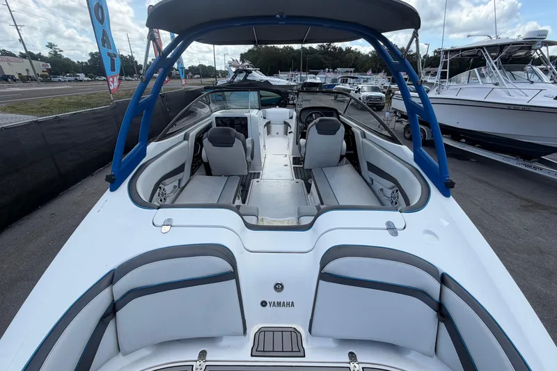 Slide: The Image of 2020 Yamaha Boats AR240 interior view with seating and helm, displayed outdoors. - 12
