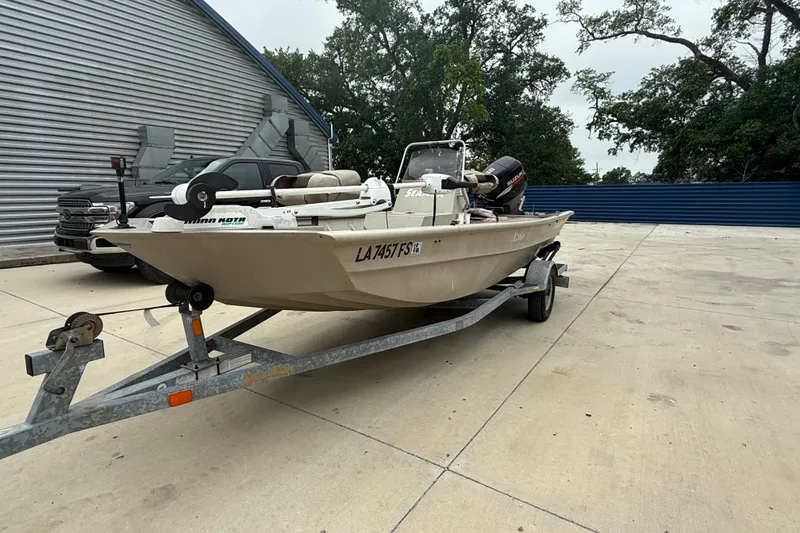 Slide: The Image of 2008 SeaArk 1652 MV boat on trailer, parked outdoors near a metal building. - 6