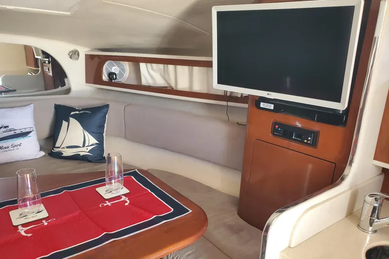 Slide: The Image of Interior of 2008 Sea Ray Sundancer 280 with TV, cushions, and table setting. - 12