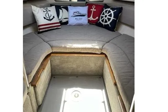 Slide: The Image of Interior of 2008 Sea Ray Sundancer 280 with nautical-themed cushions on a cozy seating area. - 14
