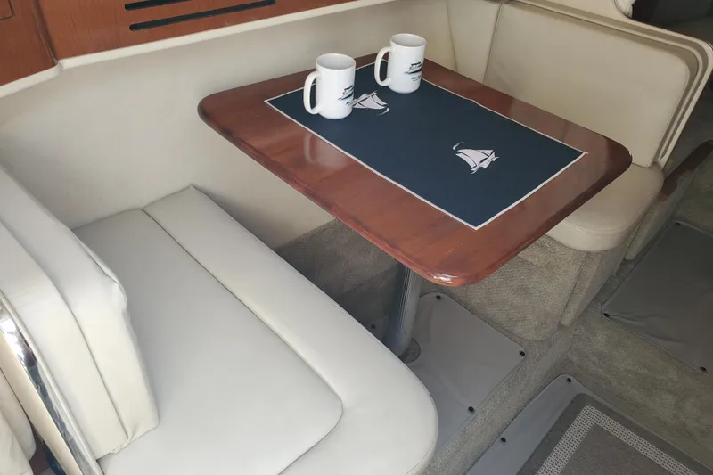 Slide: The Image of Interior of 2008 Sea Ray Sundancer 280 with table, seating, and nautical-themed decor. - 19