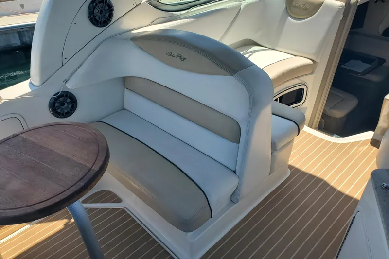 Slide: The Image of Interior of a 2008 Sea Ray Sundancer 280 with cushioned seating and a wooden table. - 8