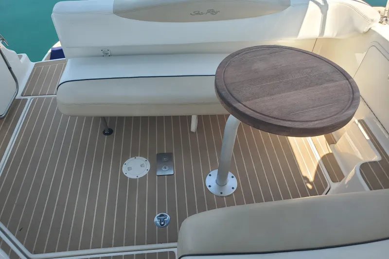 Slide: The Image of 2008 Sea Ray Sundancer 280 boat interior with cushioned seating and wooden table. - 9