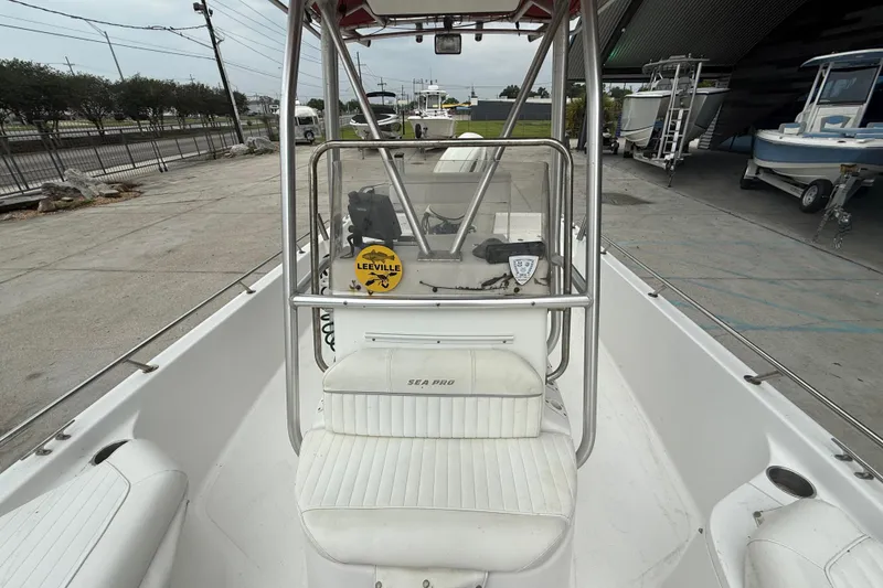 Slide: The Image of 2005 Sea Pro SV2100CC Bay Boat with center console and seating, docked outdoors. - 11