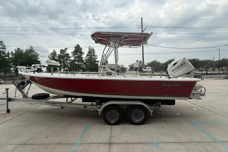 Slide: The Image of 2005 Sea Pro SV2100CC Bay Boat with Suzuki engine on trailer, red hull, overcast sky. - 5