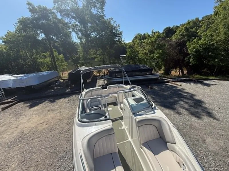 Slide: The Image of 2009 Yamaha SX 230 High Output boat on gravel lot, surrounded by trees. - 14