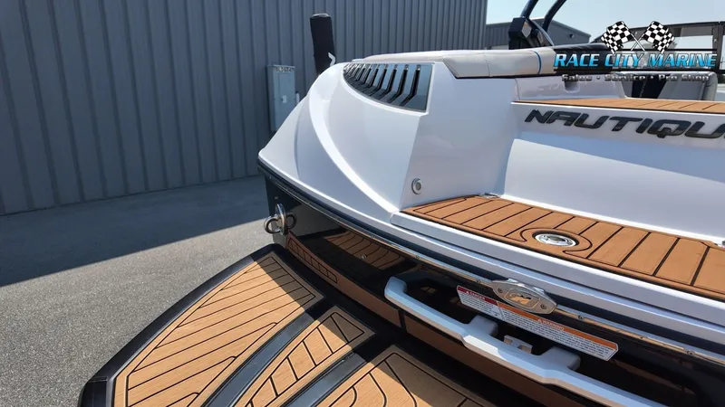 Slide: The Image of The image shows the rear of a 2015 Nautique G23 boat with wood decking and a sleek design. - 12
