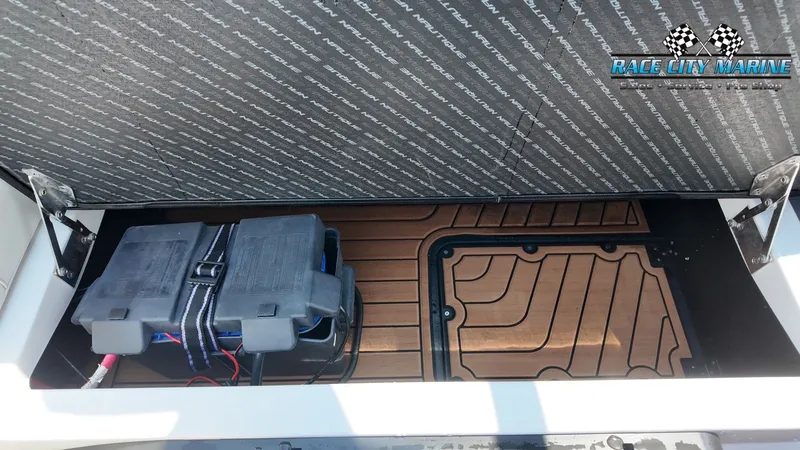 Slide: The Image of An open storage compartment in the boat reveals batteries and a textured floor mat. - 42