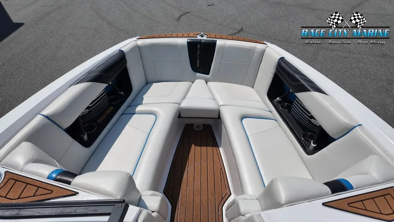 Slide: The Image of The image shows the bow area of a Nautique G23 boat with white upholstery and wood flooring. - 39