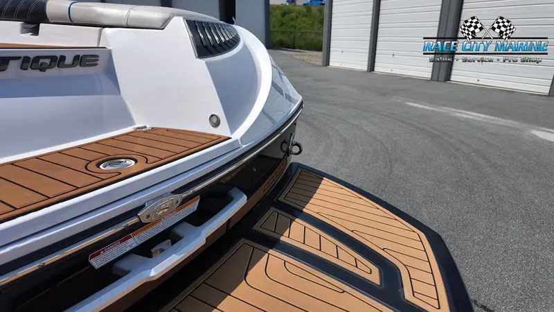 Slide: The Image of The image shows the stern of a 2015 Nautique G23 boat with a teak deck. - 13