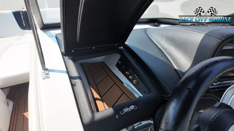 Slide: The Image of Close-up of a 2015 Nautique G23 dashboard with black and brown details. - 32