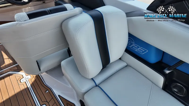Slide: The Image of The interior of a 2015 Nautique G23 with white and black seating. - 18