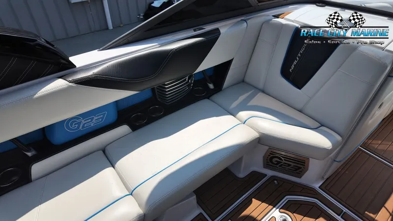 Slide: The Image of The image shows the interior of a 2015 Nautique G23 with white and blue seating. - 27