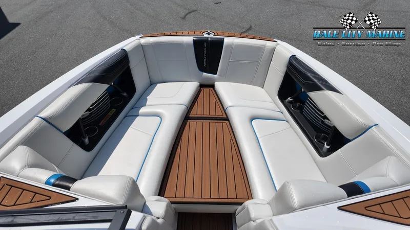 Slide: The Image of The image shows the bow area of a 2015 Nautique G23 boat with white upholstery and wood flooring. - 36
