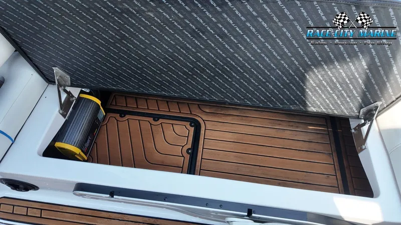 Slide: The Image of The image shows the storage area of a 2015 Nautique G23 with wooden flooring and a speaker. - 22