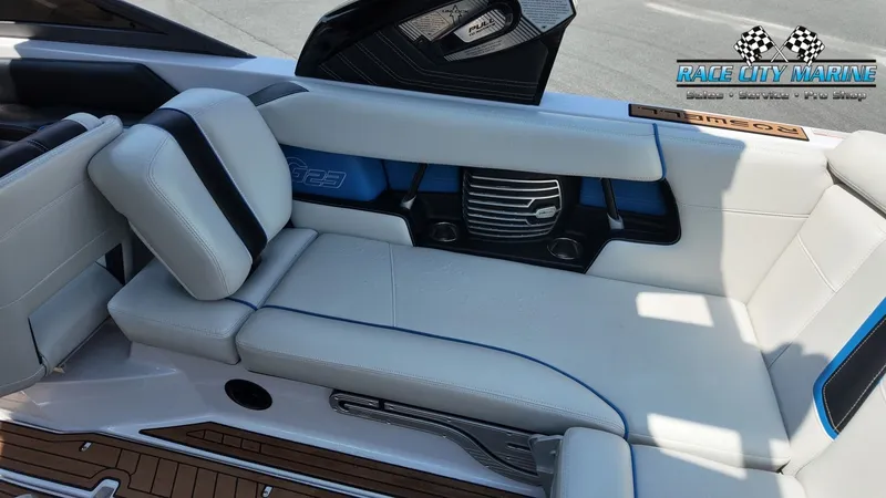 Slide: The Image of Interior of a 2015 Nautique G23 with white upholstery and blue accents. - 21