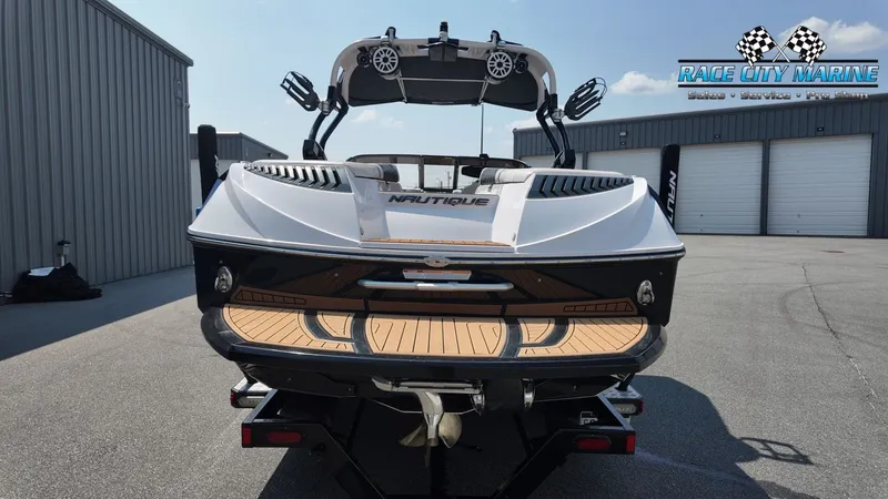 Slide: The Image of A 2015 Nautique G23 boat on a trailer, featuring sleek design and wood accents. - 4