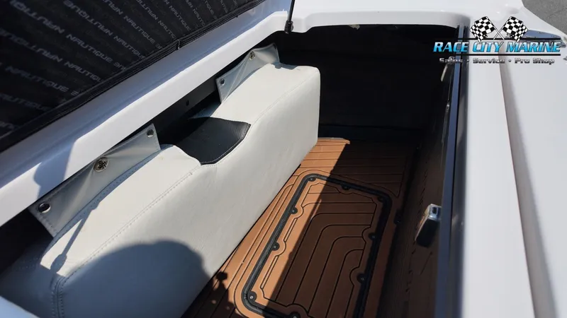 Slide: The Image of The image shows the storage area of a 2015 Nautique G23 boat with cushioned seating. - 30