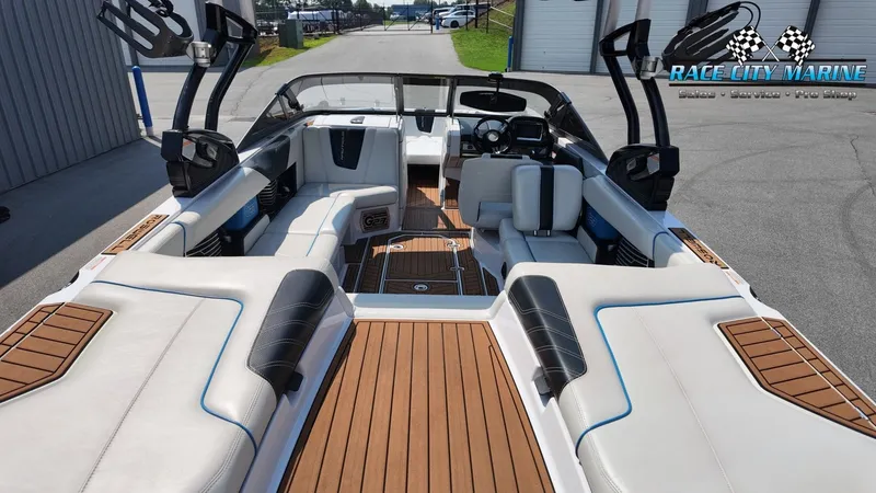 Slide: The Image of The image shows the interior of a 2015 Nautique G23 boat with luxurious seating and wood flooring. - 28