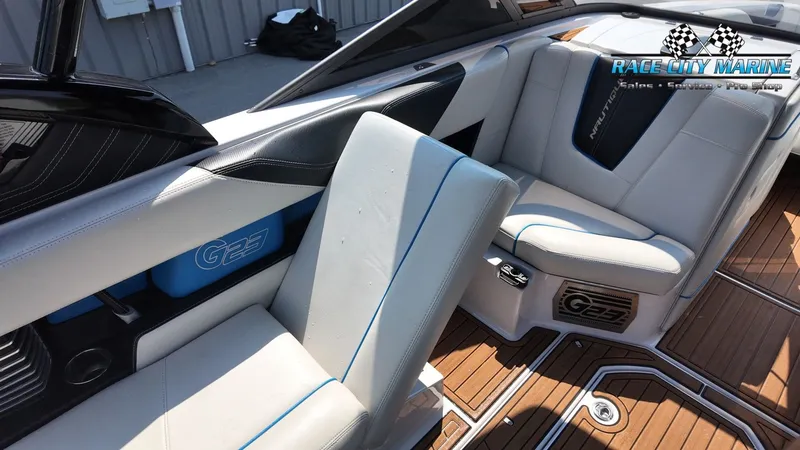 Slide: The Image of Interior of a 2015 Nautique G23 with white and blue seating and wood flooring. - 44