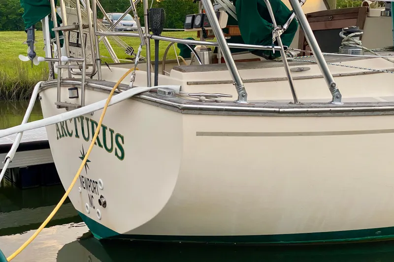 Slide: The Image of 1992 Island Packet 29 sailboat docked, featuring "Arcturus" name on stern. - 11