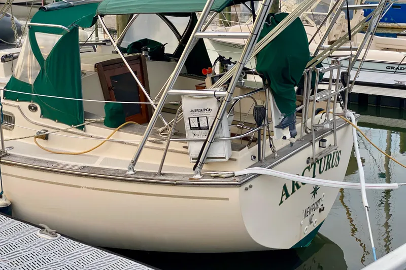 Slide: The Image of 1992 Island Packet 29 sailboat docked, featuring green canvas covers and stainless steel railings. - 16