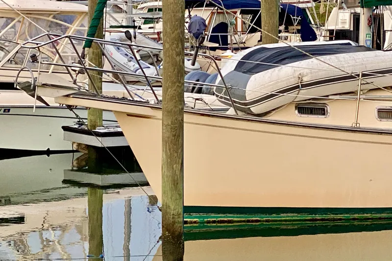 Slide: The Image of 1992 Island Packet 29 sailboat docked with inflatable dinghy on deck. - 18
