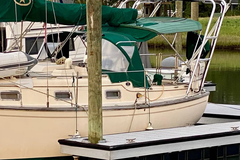 Slide: The Image of 1992 Island Packet 29 sailboat docked with green canopy and polished deck. - 19