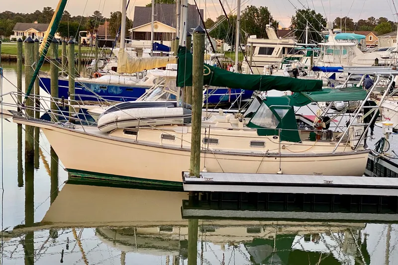 Slide: The Image of 1992 Island Packet 29 sailboat docked in a marina, surrounded by other boats. - 20
