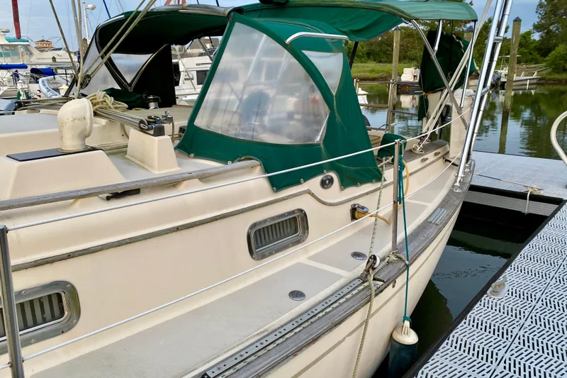 Slide: The Image of 1992 Island Packet 29 sailboat docked with green canopy and clean deck. - 23