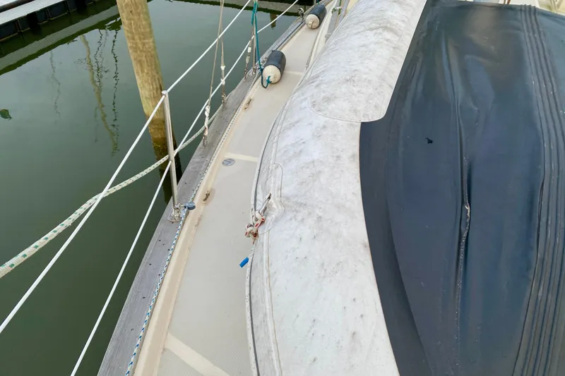 Slide: The Image of 1992 Island Packet 29 sailboat deck with railing and docked fender. - 28