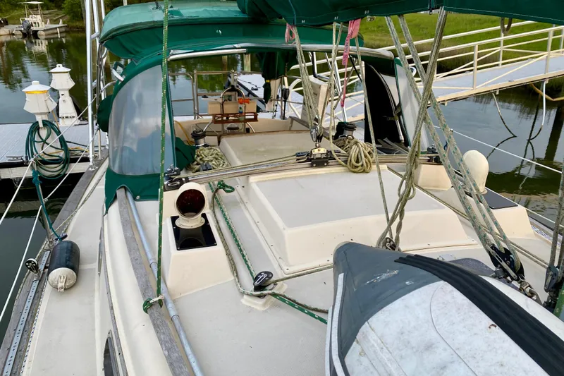 Slide: The Image of 1992 Island Packet 29 sailboat deck with green canopy, docked at marina. - 29