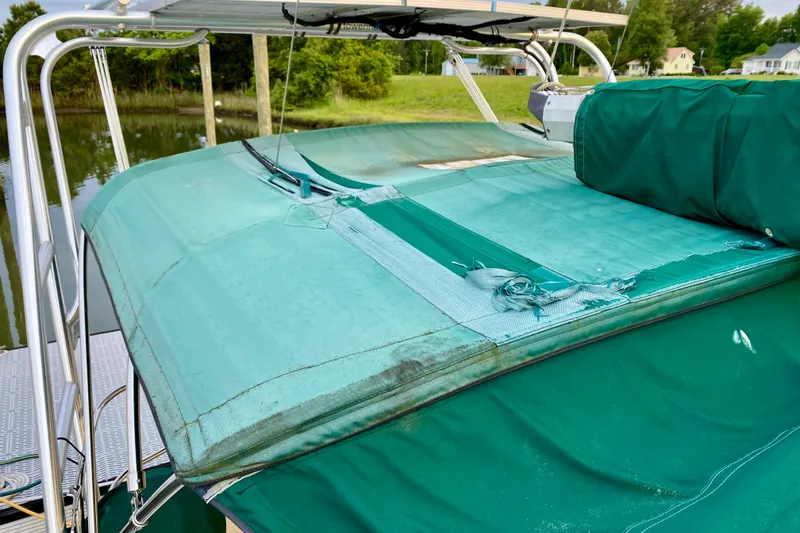Slide: The Image of Green canvas cover on 1992 Island Packet 29 sailboat, showing wear and tear. - 32