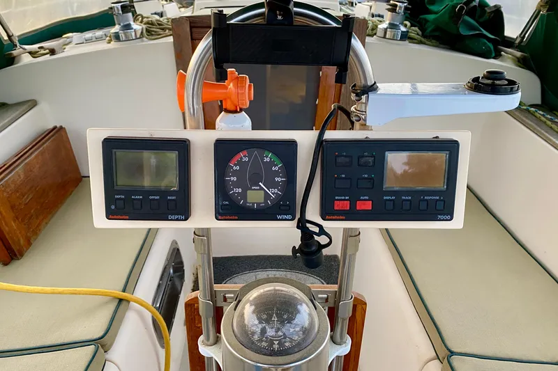 Slide: The Image of Cockpit instruments of a 1992 Island Packet 29 sailboat, featuring depth and wind gauges. - 38