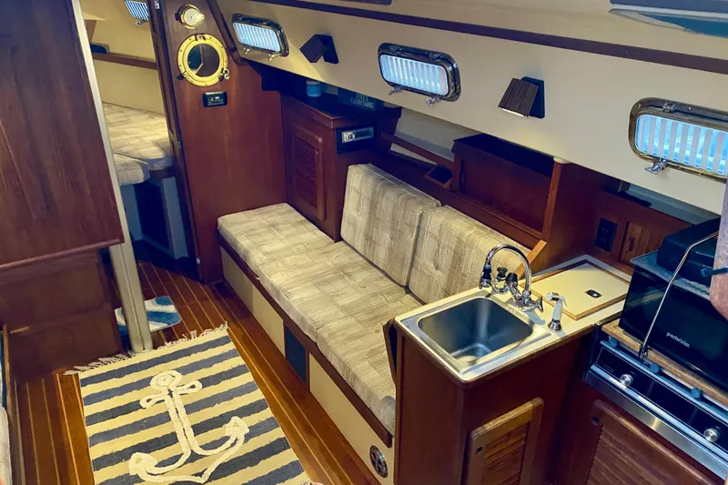 Slide: The Image of Interior of a 1992 Island Packet 29 sailboat with cozy seating and kitchenette. - 41