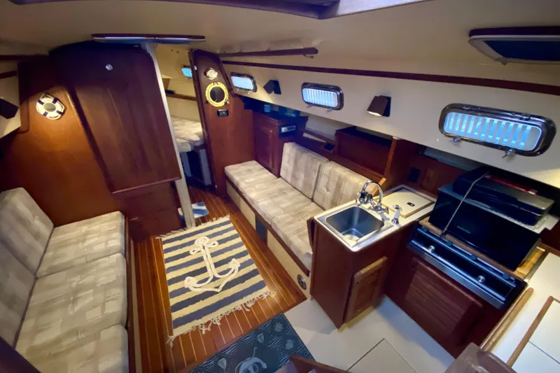 Slide: The Image of Interior of 1992 Island Packet 29 sailboat with cozy seating and compact kitchen area. - 42