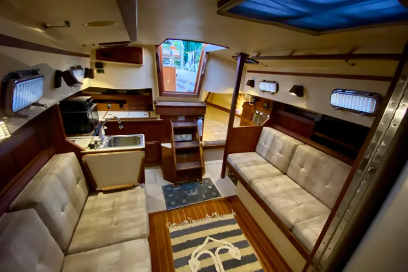 Slide: The Image of Interior of a 1992 Island Packet 29 sailboat with cozy seating and kitchenette. - 46
