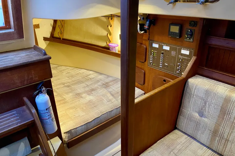 Slide: The Image of Interior of a 1992 Island Packet 29 sailboat, featuring a cozy cabin and control panel. - 51