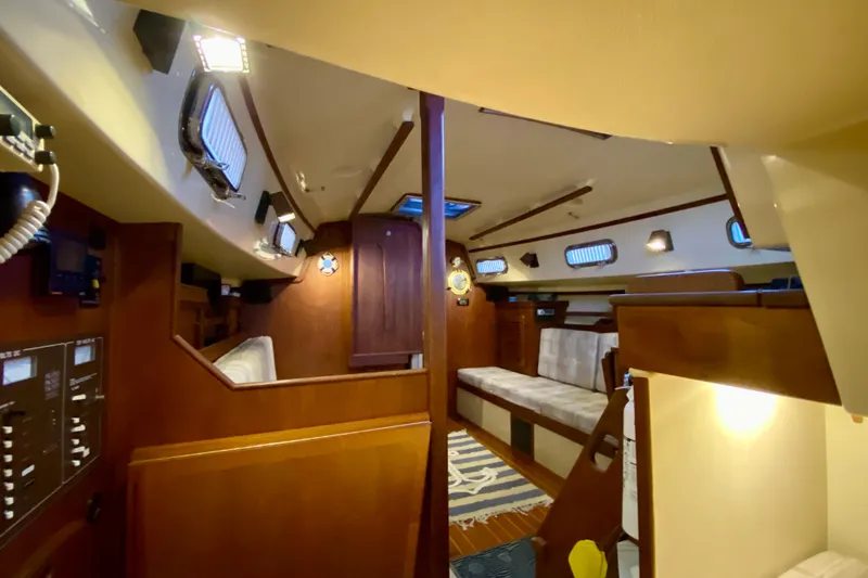 Slide: The Image of Interior of a 1992 Island Packet 29 sailboat, featuring cozy wooden furnishings and seating. - 54