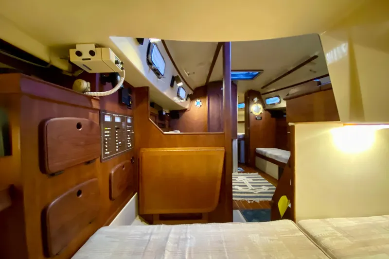 Slide: The Image of Interior of a 1992 Island Packet 29 sailboat, featuring cozy wooden cabinetry and seating. - 55