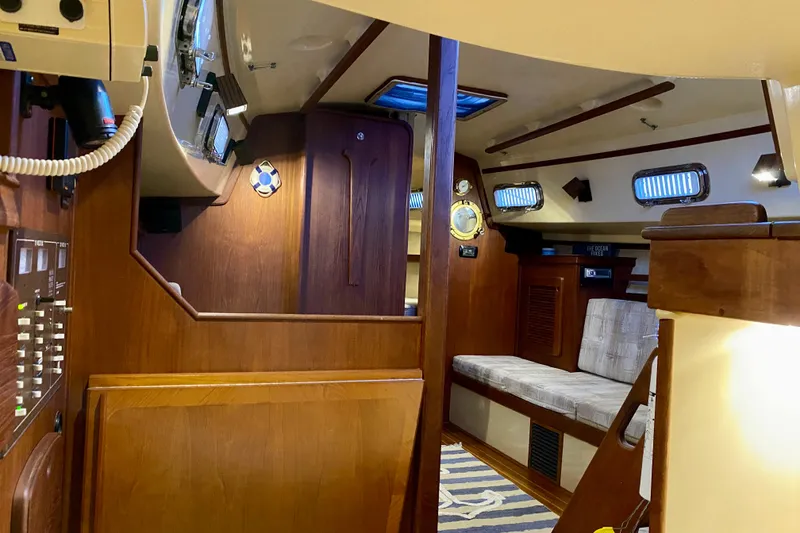 Slide: The Image of 1992 Island Packet 29 sailboat interior with wood paneling and seating area. - 56