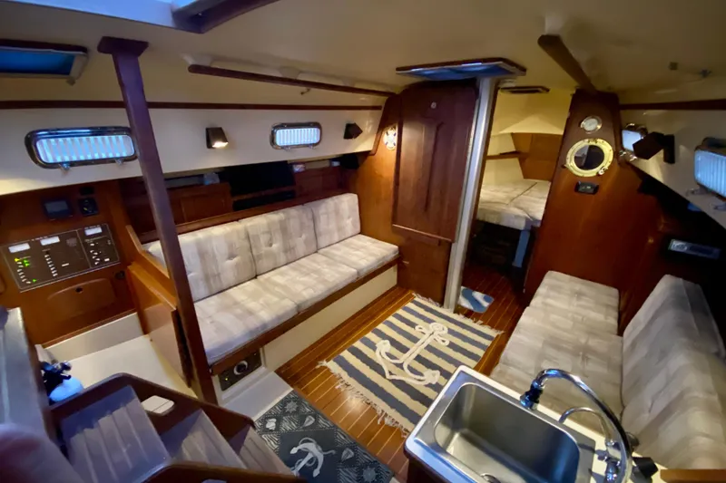 Slide: The Image of Interior of a 1992 Island Packet 29 sailboat with cozy seating and nautical decor. - 58