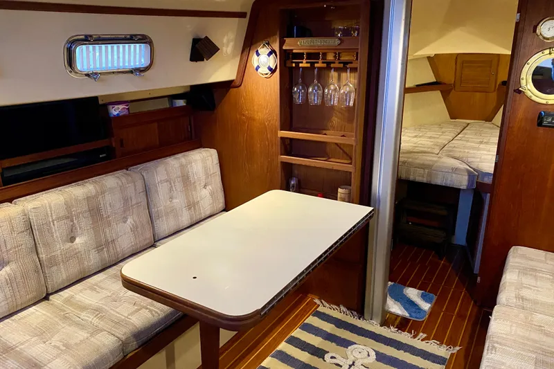 Slide: The Image of Cozy interior of a 1992 Island Packet 29 sailboat with dining area and cabin. - 60