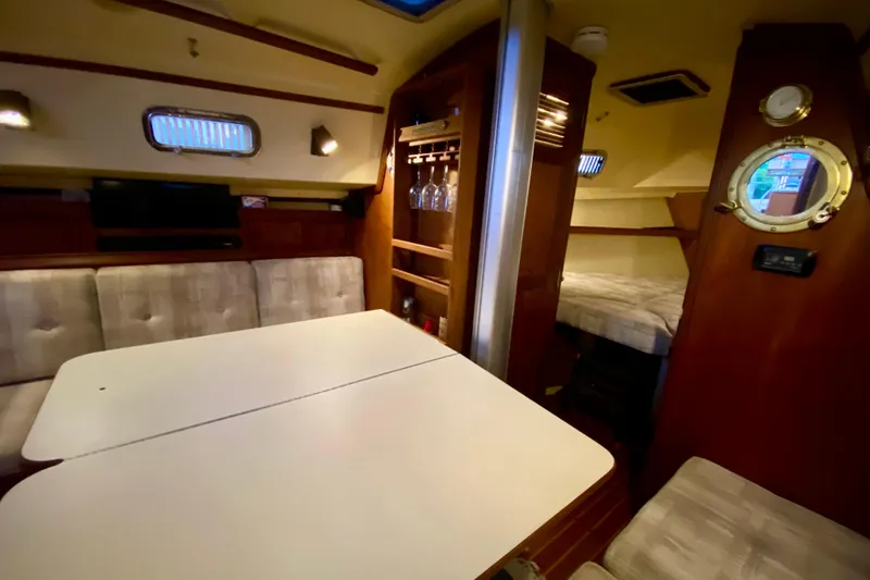 Slide: The Image of Interior of 1992 Island Packet 29 sailboat with dining area and cozy sleeping quarters. - 61