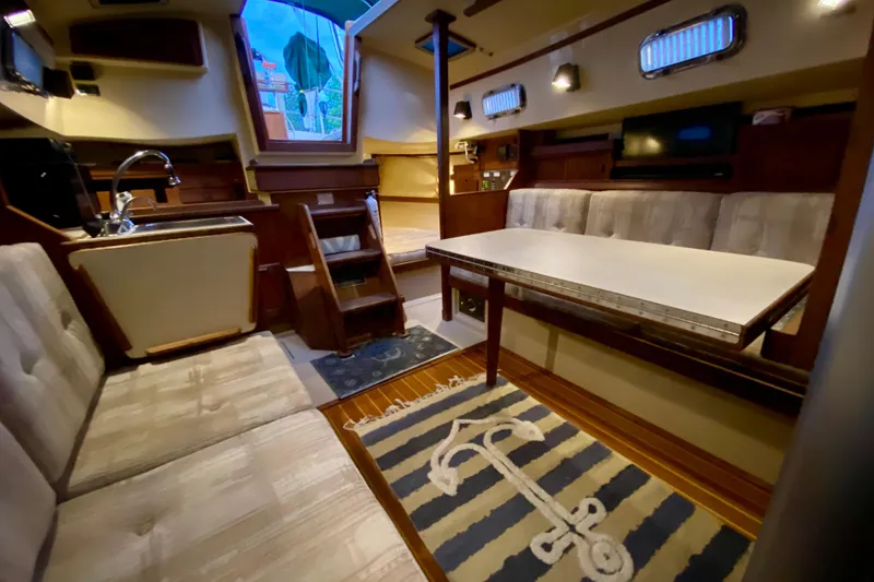 Slide: The Image of Interior of a 1992 Island Packet 29 sailboat with cozy seating and nautical decor. - 63