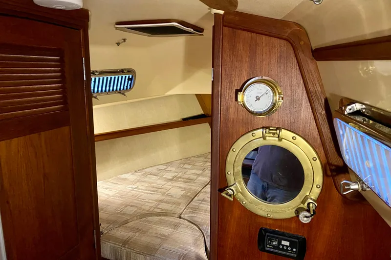 Slide: The Image of Interior of 1992 Island Packet 29 sailboat with wooden door and brass porthole. - 66