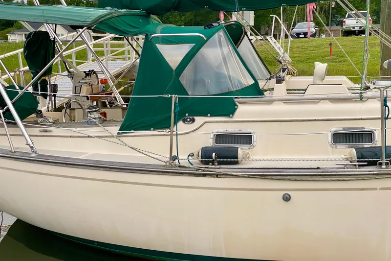 Slide: The Image of 1992 Island Packet 29 sailboat docked with green canopy and railing. - 7