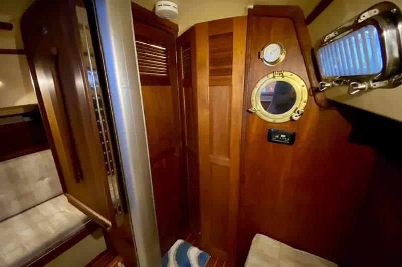 Slide: The Image of Interior of 1992 Island Packet 29 sailboat with wooden paneling and porthole window. - 70