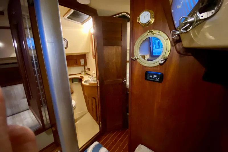 Slide: The Image of Interior of 1992 Island Packet 29 sailboat, featuring wooden cabinetry and nautical decor. - 71