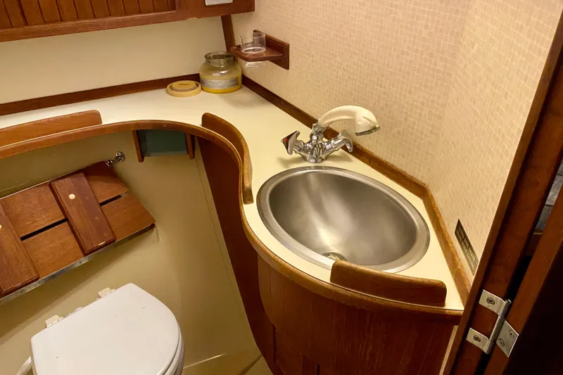 Slide: The Image of Compact bathroom in 1992 Island Packet 29 sailboat with sink and wooden accents. - 72